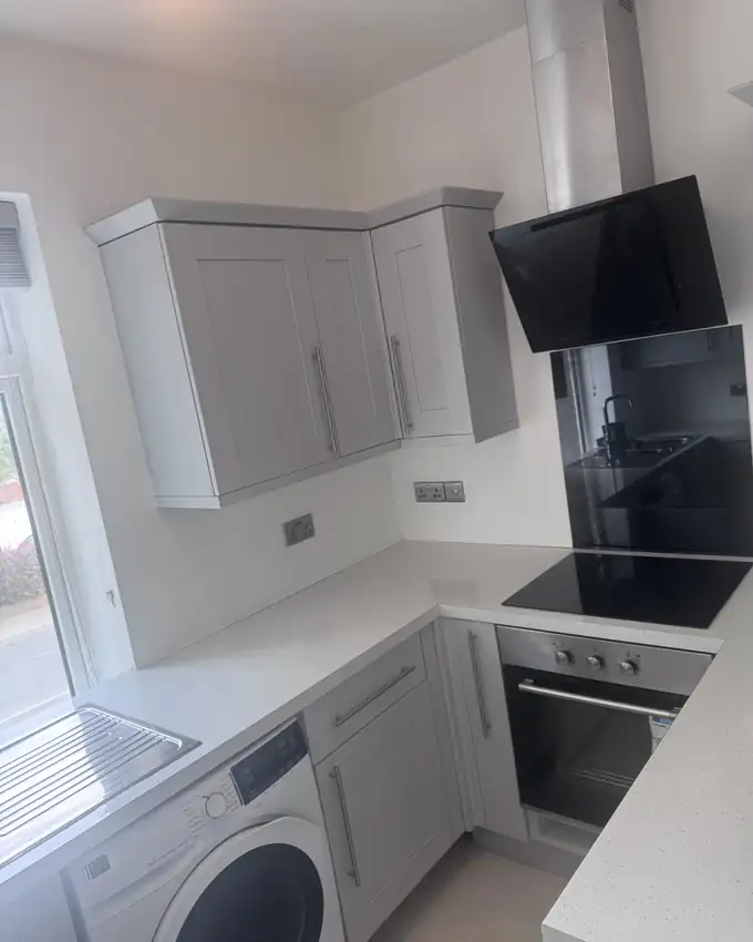 A cleaned kitchen with clear worktops, wiped units, polished hob and oven ready for handover